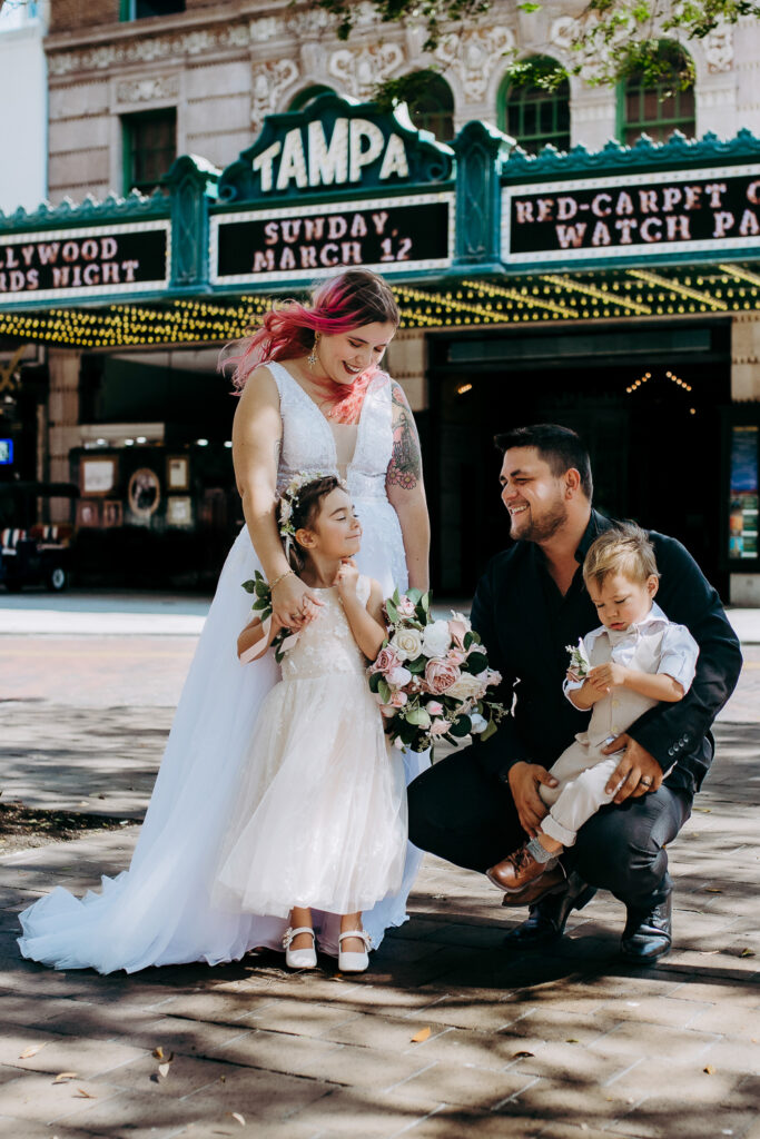 bride and groom hugging their children outside the tamap theatre after their tampa courthouse wedding