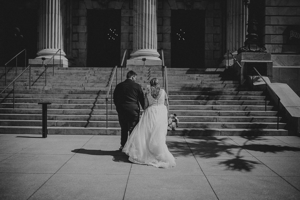 bride and groom are walking up the stairsto their tampa courthouse wedding 