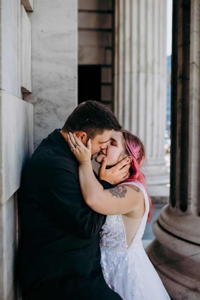 bride and groom kissing against the wall after their tampa courthouse wedding
