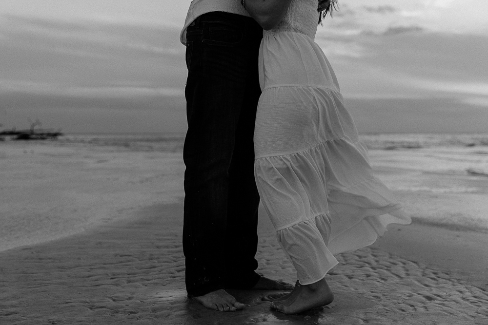 couple embracing on the beach on anna maria island outside of sarasota florida