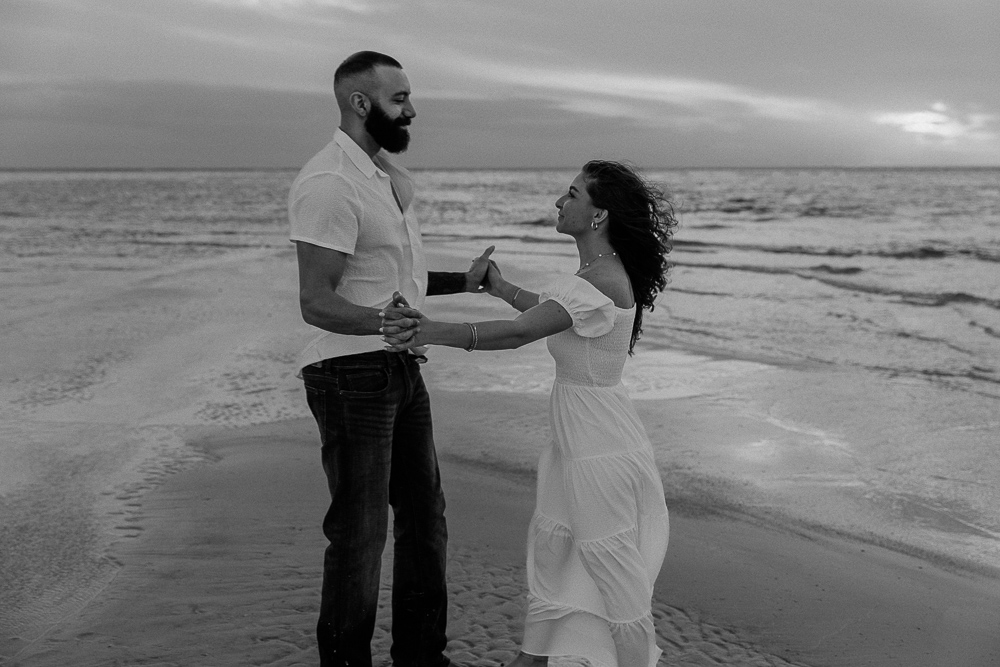 couple embracing on the beach on anna maria island outside of sarasota florida