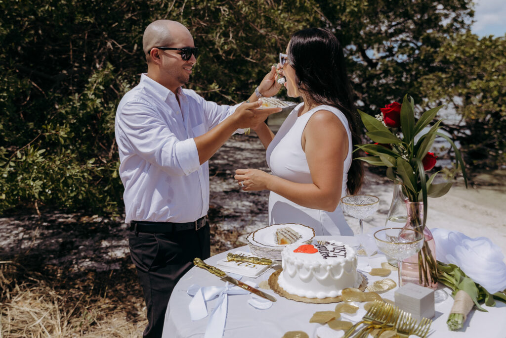 tampa elopement photographer taking a photo of couple celebrating with cake 