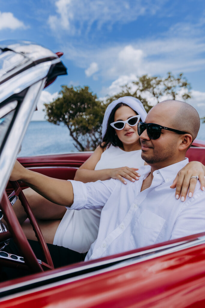 eloping couple taking a photo in a vintage ford mustage 