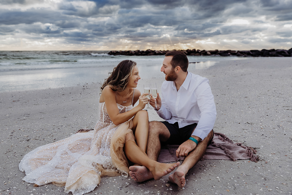 newly engaged couple eating pizza on st pete beach during their engagement session with a tampa wedding photographer