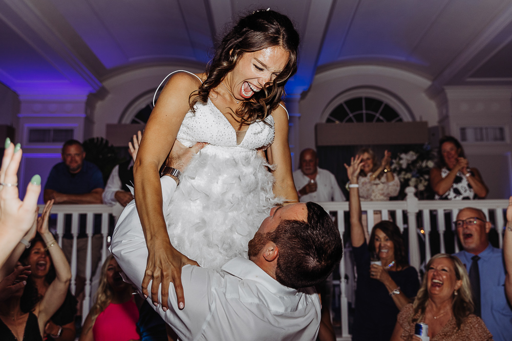 groom picking bride up to dance at the reception at the don cesar hotel