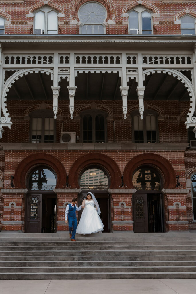 couple walking together down stairs after their elopement in plant park tampa 
