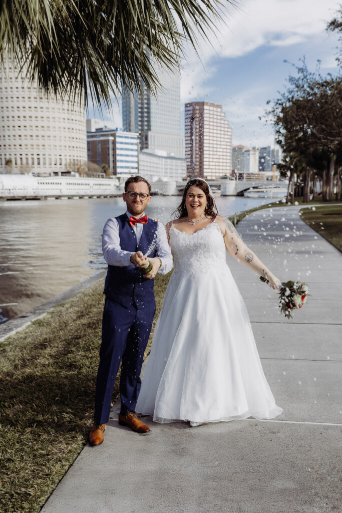 couple popping champagne after their florida elopement