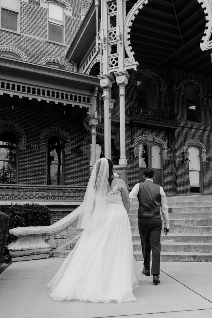 couple walking up stairs for portraits for their florida elopement in plant park tampa 