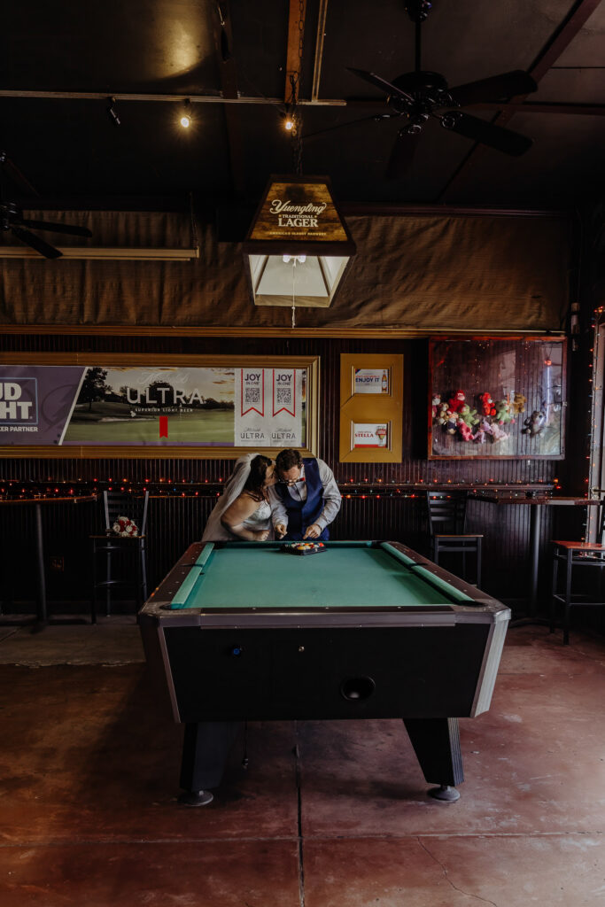 couple playing pool after their florida elopement 