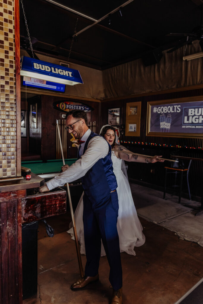 couple playing pool after eloping 