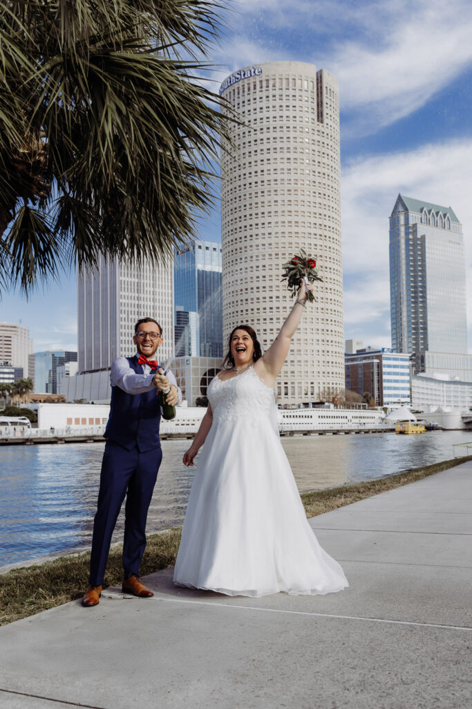 couple popping champagne to celebrate their courthouse elopement in tampa