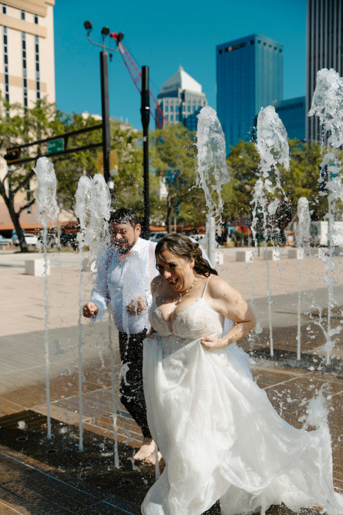 couple running in water in downtown tampa after their courthouse elopement in tampa