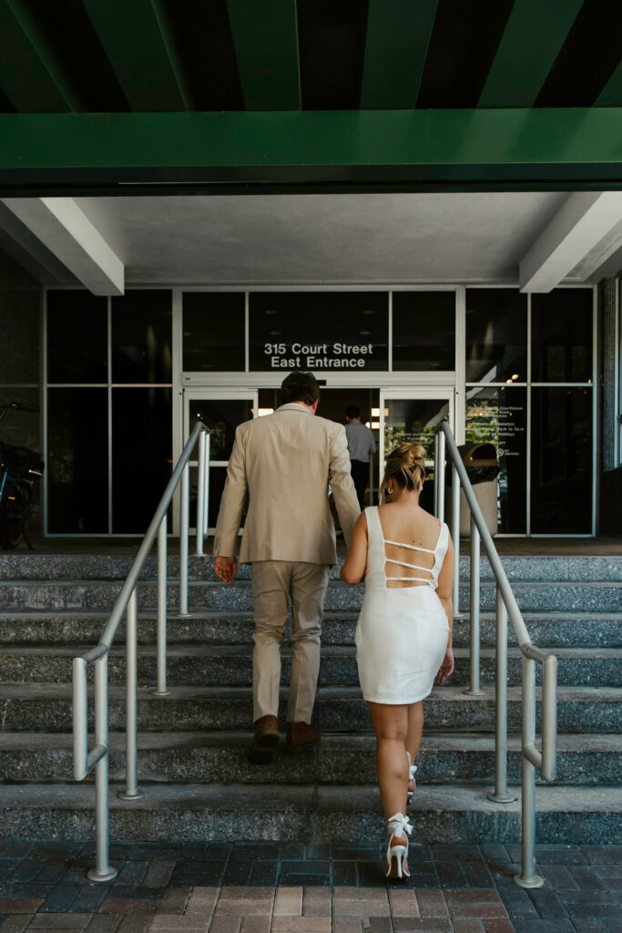 a photo of couple walking in the courthouse for their elopement 
