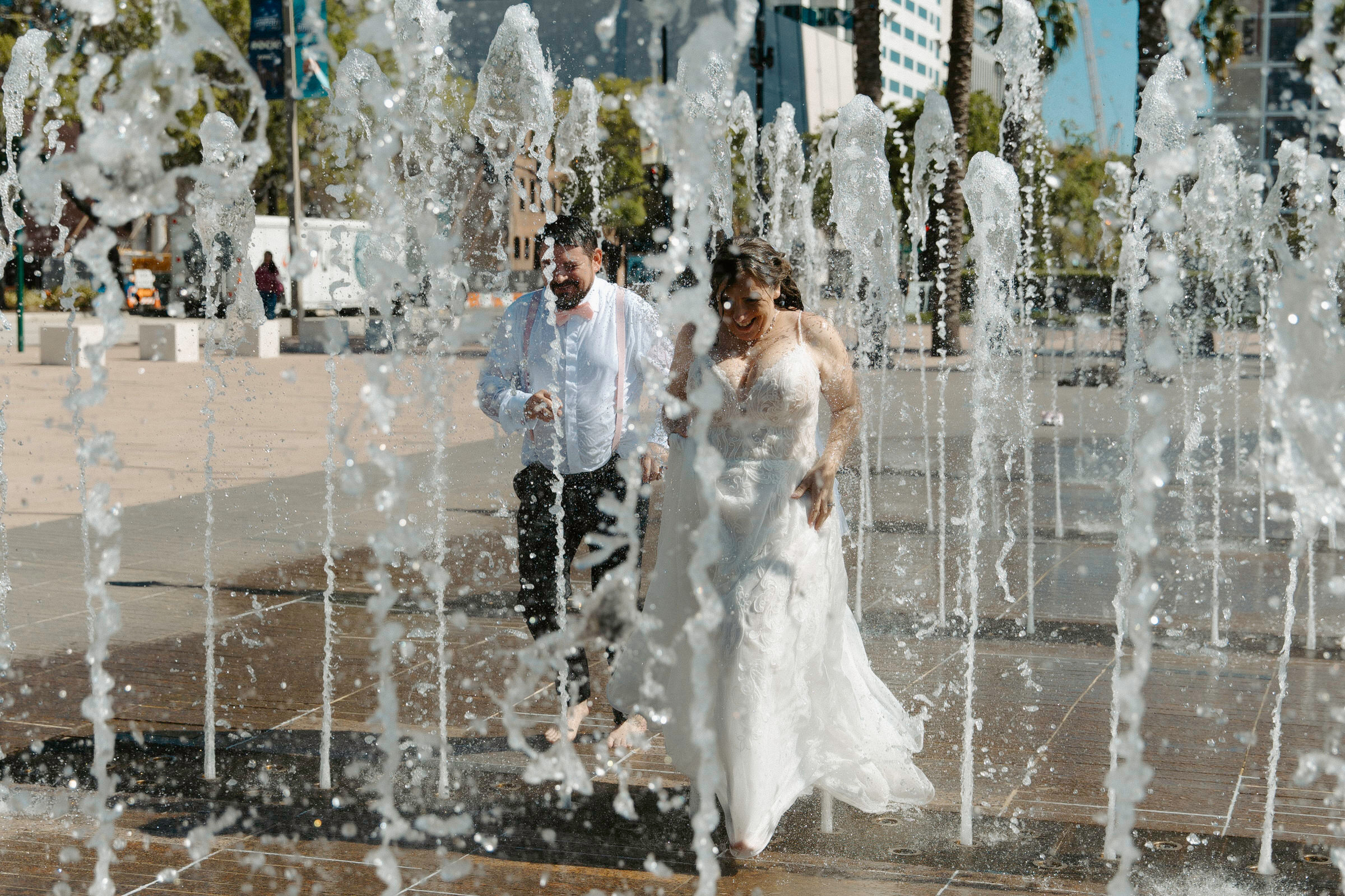 couple running through sprinklers after their courthouse elopement in tampa