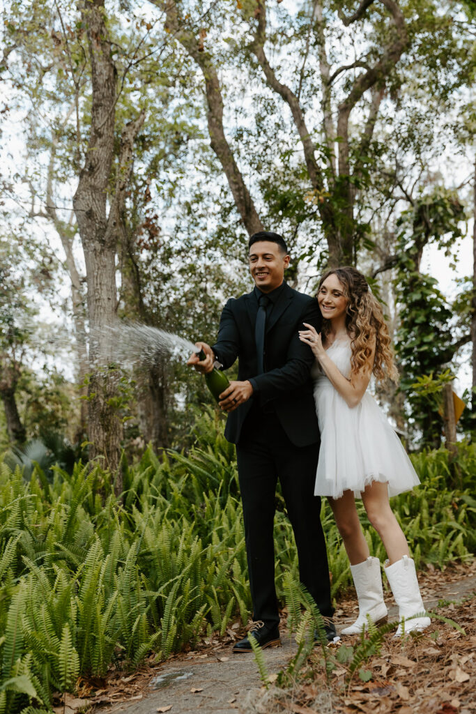 couple popping chamgne after their elopement outside of tampa