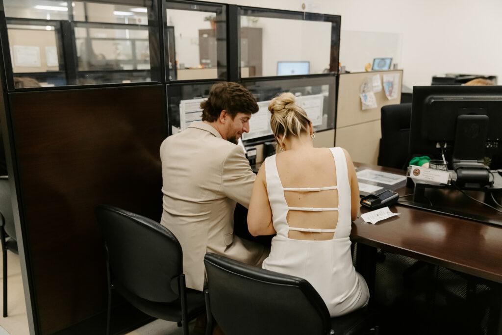 couple is signing their paperwork before their clearwater courthouse wedding 