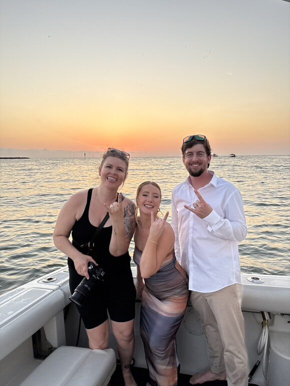 selfie of tampa elopement photographer and her clients at sunset on a boat 