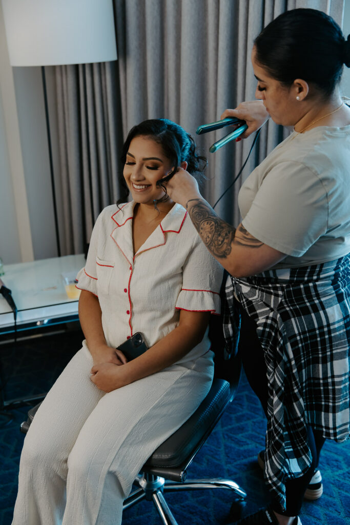 bride getting her hair finished while getting ready for her wedding 