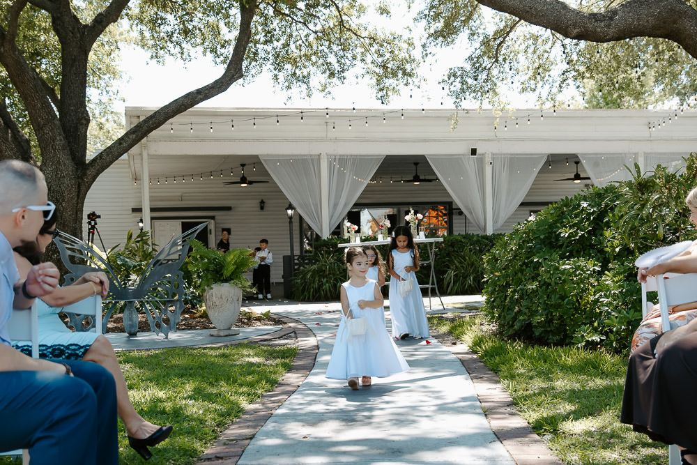 flower girls walking down the aisle during the wedding ceremony