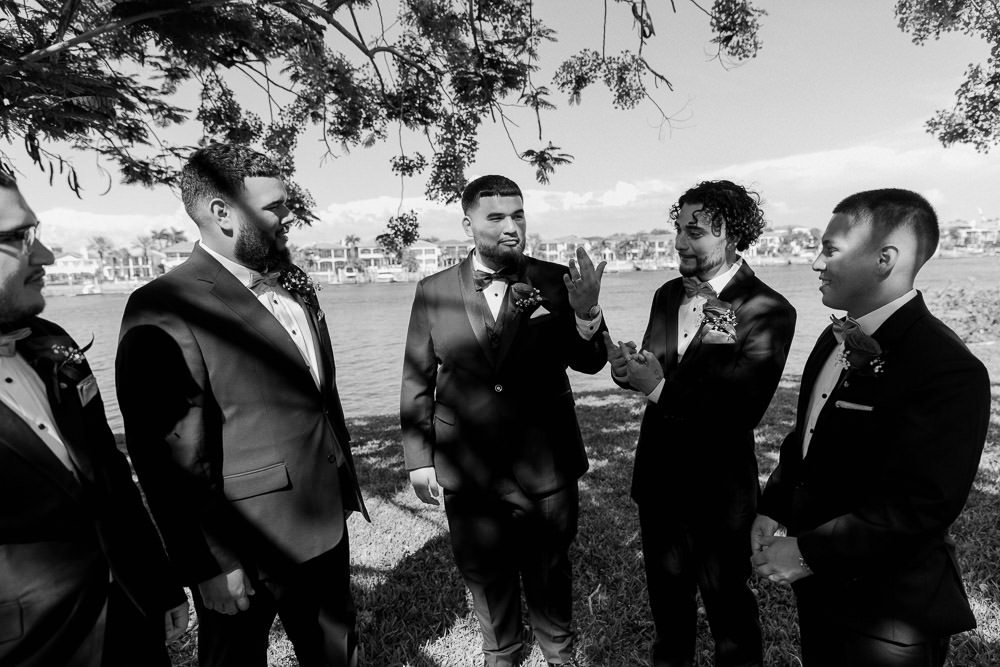 groomsmen with the groom having a candid moment gushing over his ring 