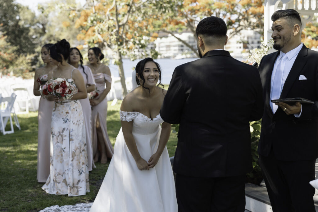 bride laughing at her grooms vows during their ceremony at davis island garden club